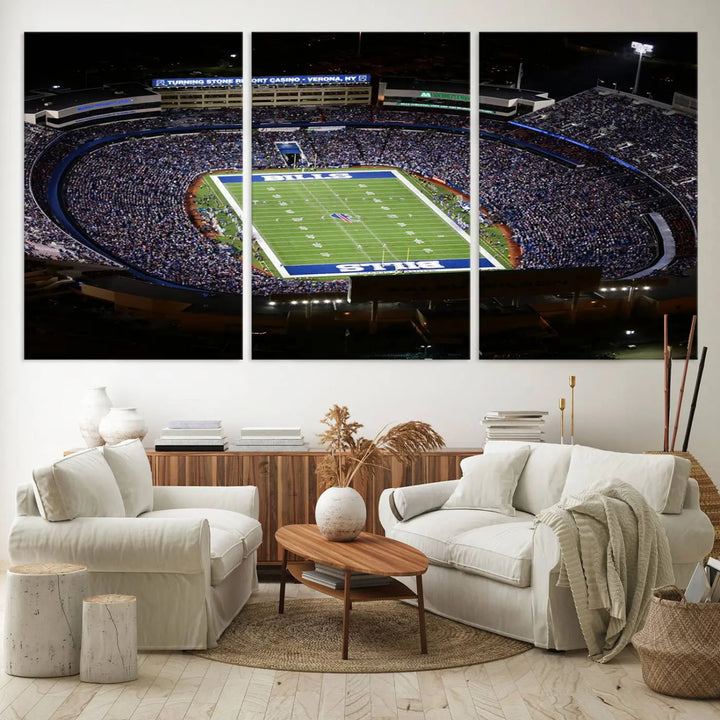 Above the couch hangs a museum-quality triptych featuring the Buffalo Bills NFL Football Team: a stunning canvas print of Highmark Stadium packed with enthusiastic spectators at night. The high-resolution printing technique captures every detail to perfection, making it ready to hang and instantly elevate any space.