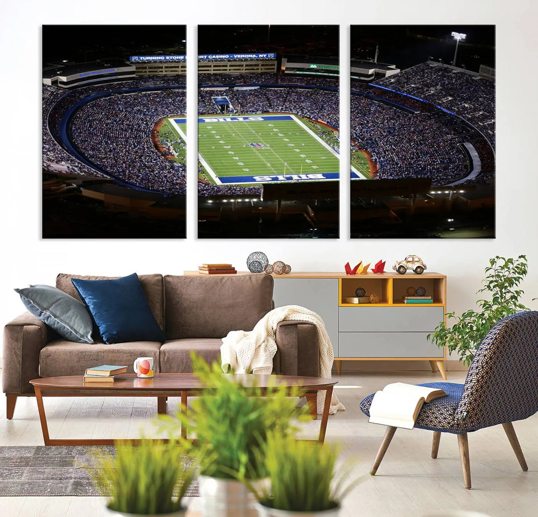 Above the couch hangs a museum-quality triptych featuring the Buffalo Bills NFL Football Team: a stunning canvas print of Highmark Stadium packed with enthusiastic spectators at night. The high-resolution printing technique captures every detail to perfection, making it ready to hang and instantly elevate any space.