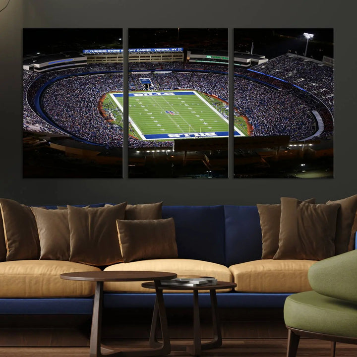 Above the couch hangs a museum-quality triptych featuring the Buffalo Bills NFL Football Team: a stunning canvas print of Highmark Stadium packed with enthusiastic spectators at night. The high-resolution printing technique captures every detail to perfection, making it ready to hang and instantly elevate any space.