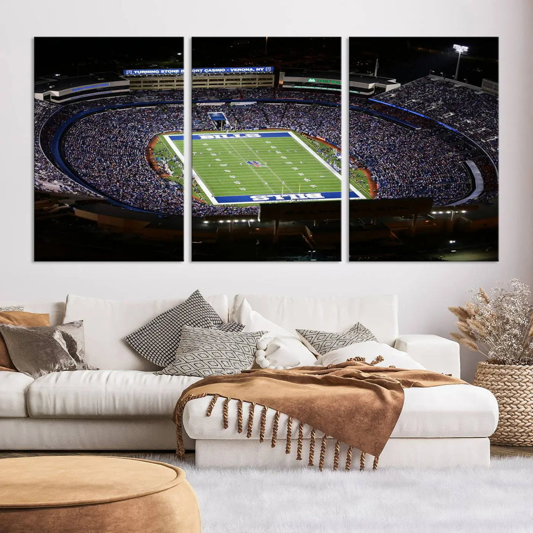 Above the couch hangs a museum-quality triptych featuring the Buffalo Bills NFL Football Team: a stunning canvas print of Highmark Stadium packed with enthusiastic spectators at night. The high-resolution printing technique captures every detail to perfection, making it ready to hang and instantly elevate any space.