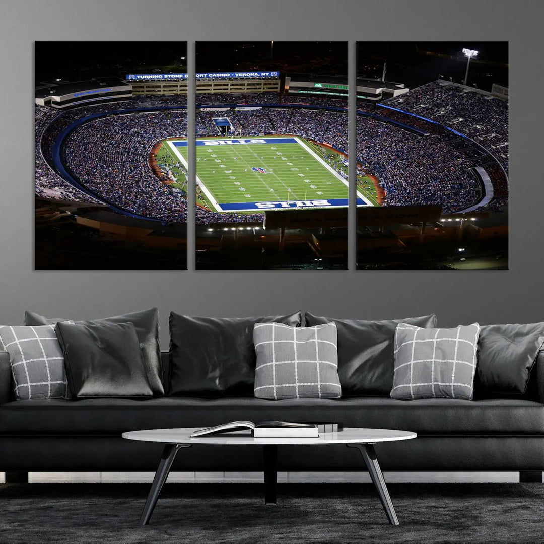 Above the couch hangs a museum-quality triptych featuring the Buffalo Bills NFL Football Team: a stunning canvas print of Highmark Stadium packed with enthusiastic spectators at night. The high-resolution printing technique captures every detail to perfection, making it ready to hang and instantly elevate any space.