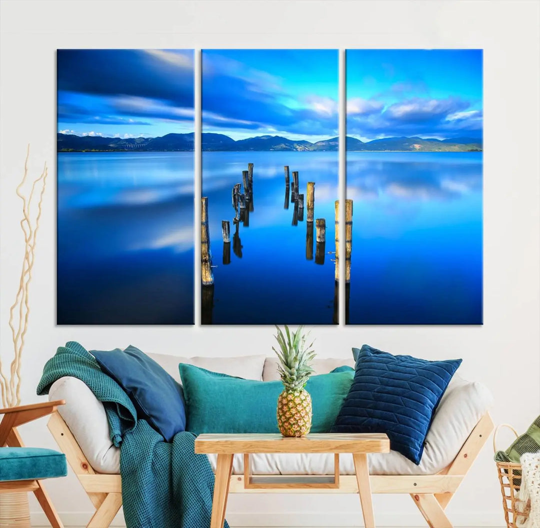 The Calm Waters Lake Canvas Art, featuring a tranquil pier reflection set against a mountainous backdrop, showcases its elegance with a gallery wrap and Canon print quality.