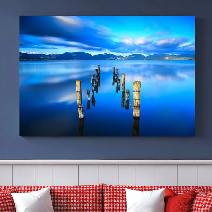 The Calm Waters Lake Canvas Art, featuring a tranquil pier reflection set against a mountainous backdrop, showcases its elegance with a gallery wrap and Canon print quality.