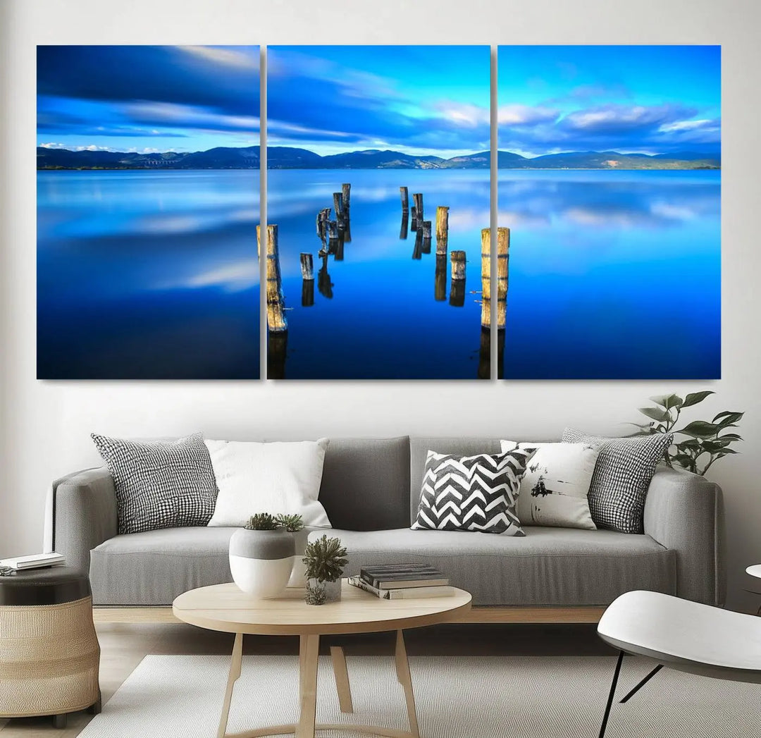 The Calm Waters Lake Canvas Art, featuring a tranquil pier reflection set against a mountainous backdrop, showcases its elegance with a gallery wrap and Canon print quality.