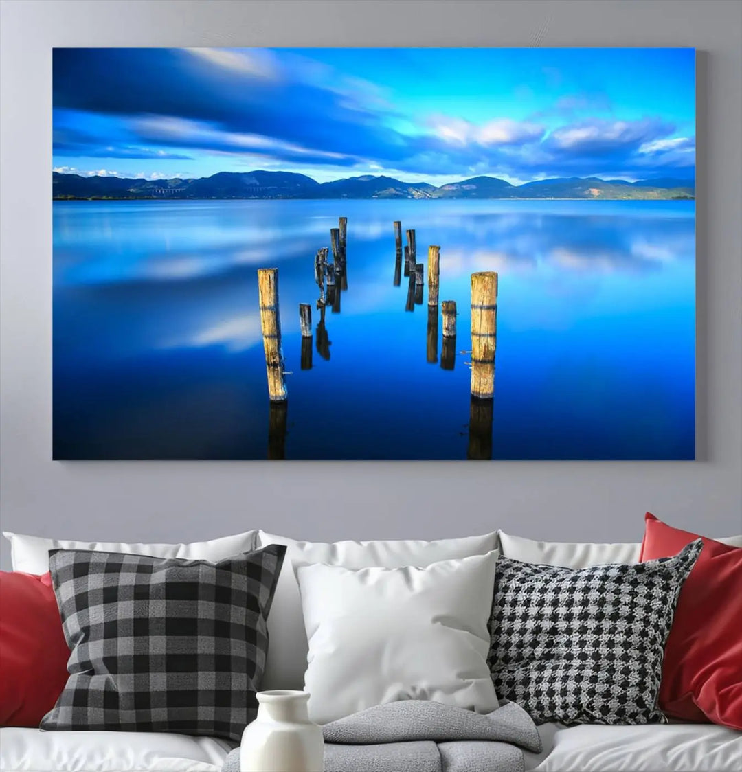 The Calm Waters Lake Canvas Art, featuring a tranquil pier reflection set against a mountainous backdrop, showcases its elegance with a gallery wrap and Canon print quality.