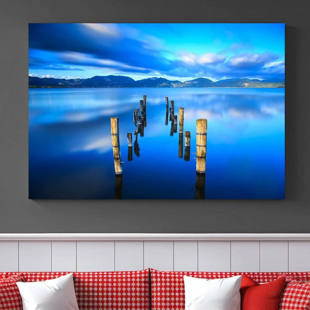 The Calm Waters Lake Canvas Art, featuring a tranquil pier reflection set against a mountainous backdrop, showcases its elegance with a gallery wrap and Canon print quality.