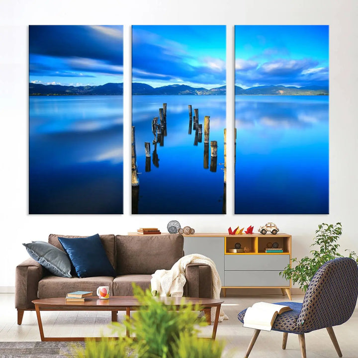 The Calm Waters Lake Canvas Art, featuring a tranquil pier reflection set against a mountainous backdrop, showcases its elegance with a gallery wrap and Canon print quality.