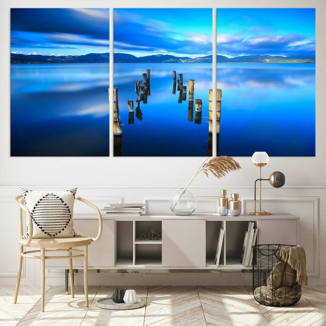 The Calm Waters Lake Canvas Art, featuring a tranquil pier reflection set against a mountainous backdrop, showcases its elegance with a gallery wrap and Canon print quality.