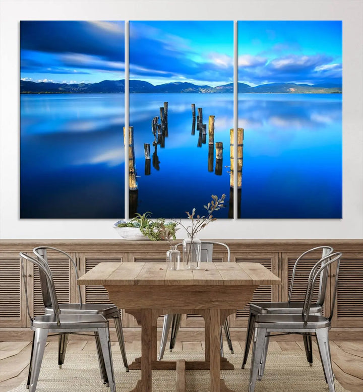 The Calm Waters Lake Canvas Art, featuring a tranquil pier reflection set against a mountainous backdrop, showcases its elegance with a gallery wrap and Canon print quality.