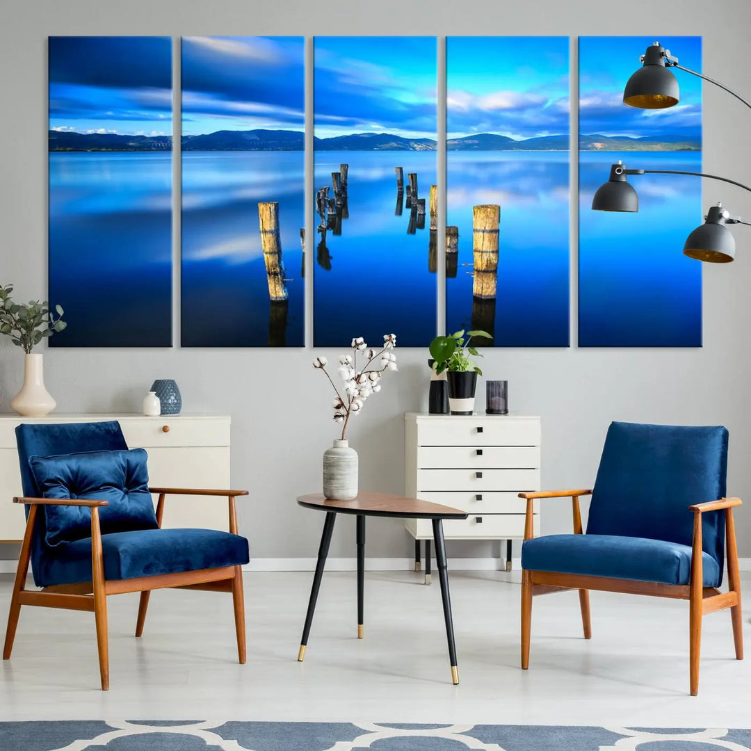 The Calm Waters Lake Canvas Art, featuring a tranquil pier reflection set against a mountainous backdrop, showcases its elegance with a gallery wrap and Canon print quality.