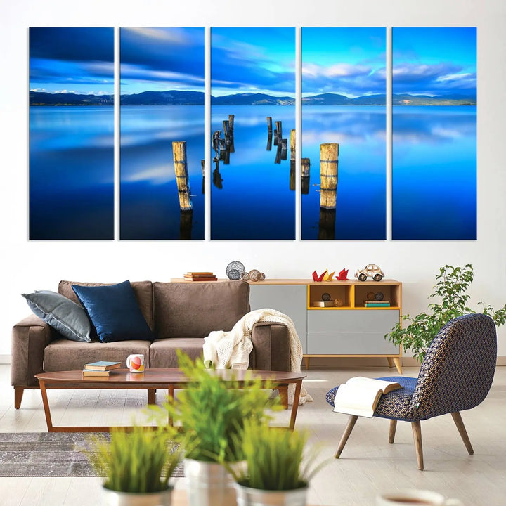 The Calm Waters Lake Canvas Art, featuring a tranquil pier reflection set against a mountainous backdrop, showcases its elegance with a gallery wrap and Canon print quality.