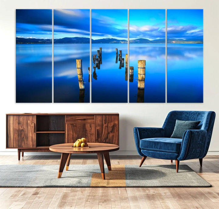 The Calm Waters Lake Canvas Art, featuring a tranquil pier reflection set against a mountainous backdrop, showcases its elegance with a gallery wrap and Canon print quality.