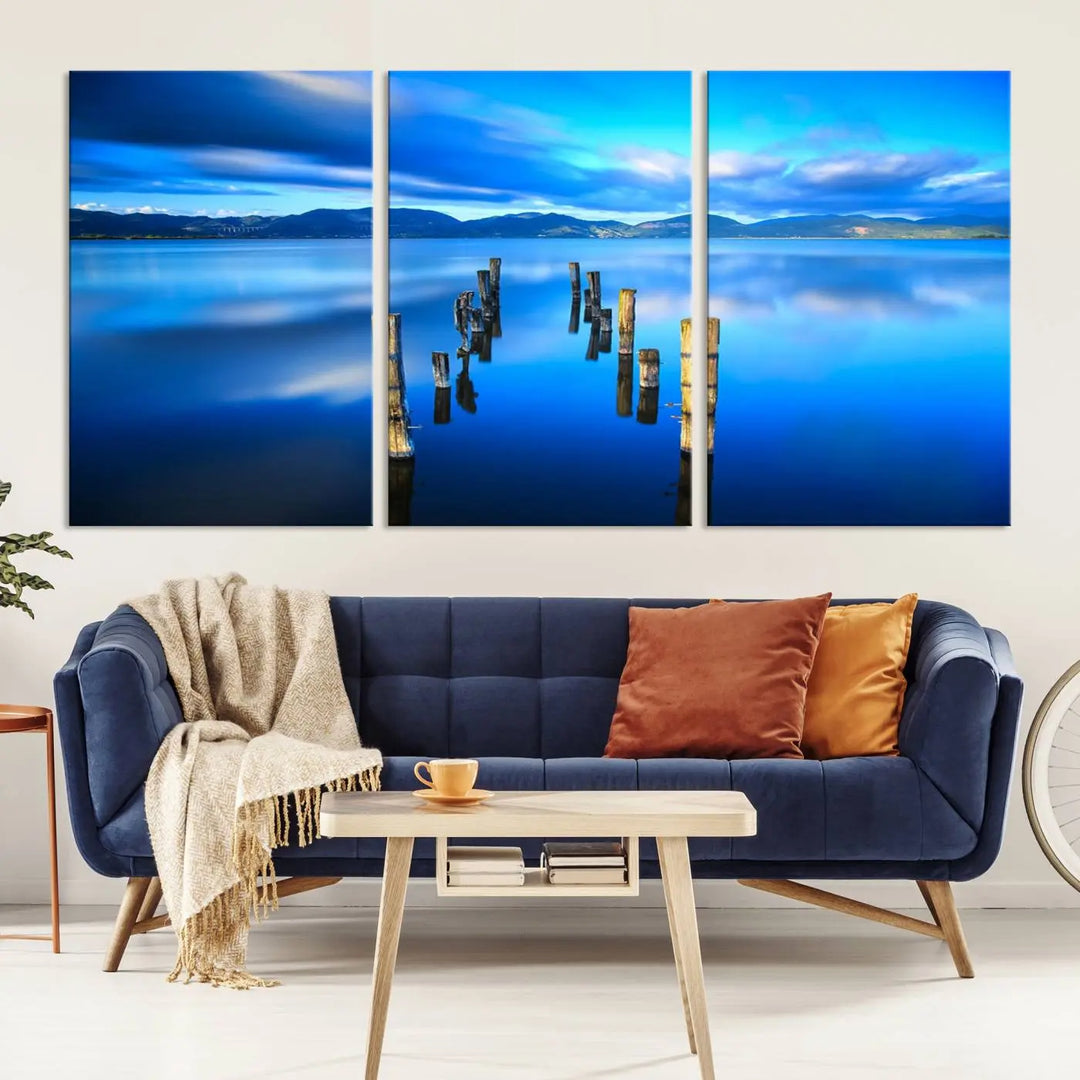 The Calm Waters Lake Canvas Art, featuring a tranquil pier reflection set against a mountainous backdrop, showcases its elegance with a gallery wrap and Canon print quality.