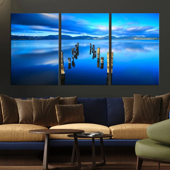 The Calm Waters Lake Canvas Art, featuring a tranquil pier reflection set against a mountainous backdrop, showcases its elegance with a gallery wrap and Canon print quality.