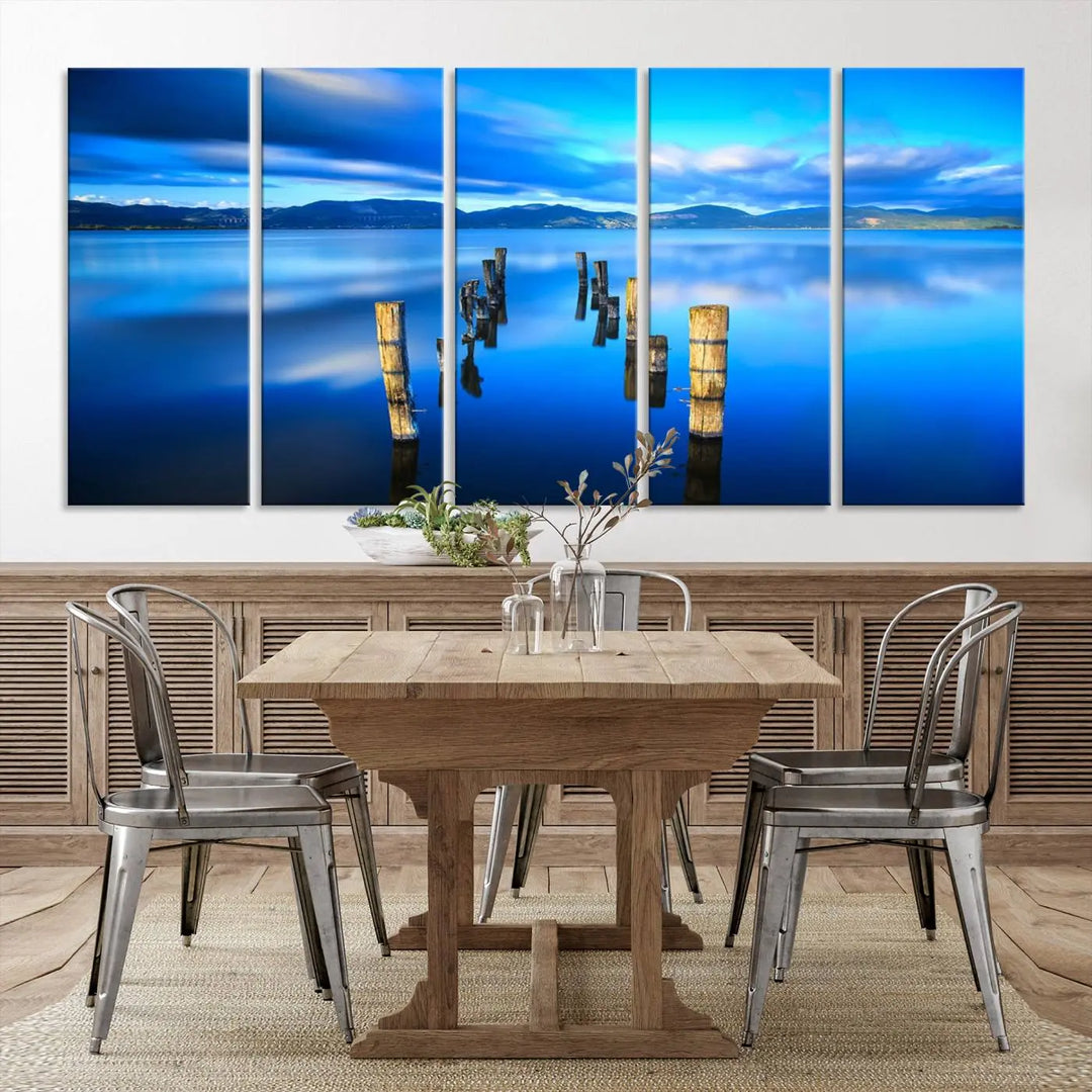 The Calm Waters Lake Canvas Art, featuring a tranquil pier reflection set against a mountainous backdrop, showcases its elegance with a gallery wrap and Canon print quality.