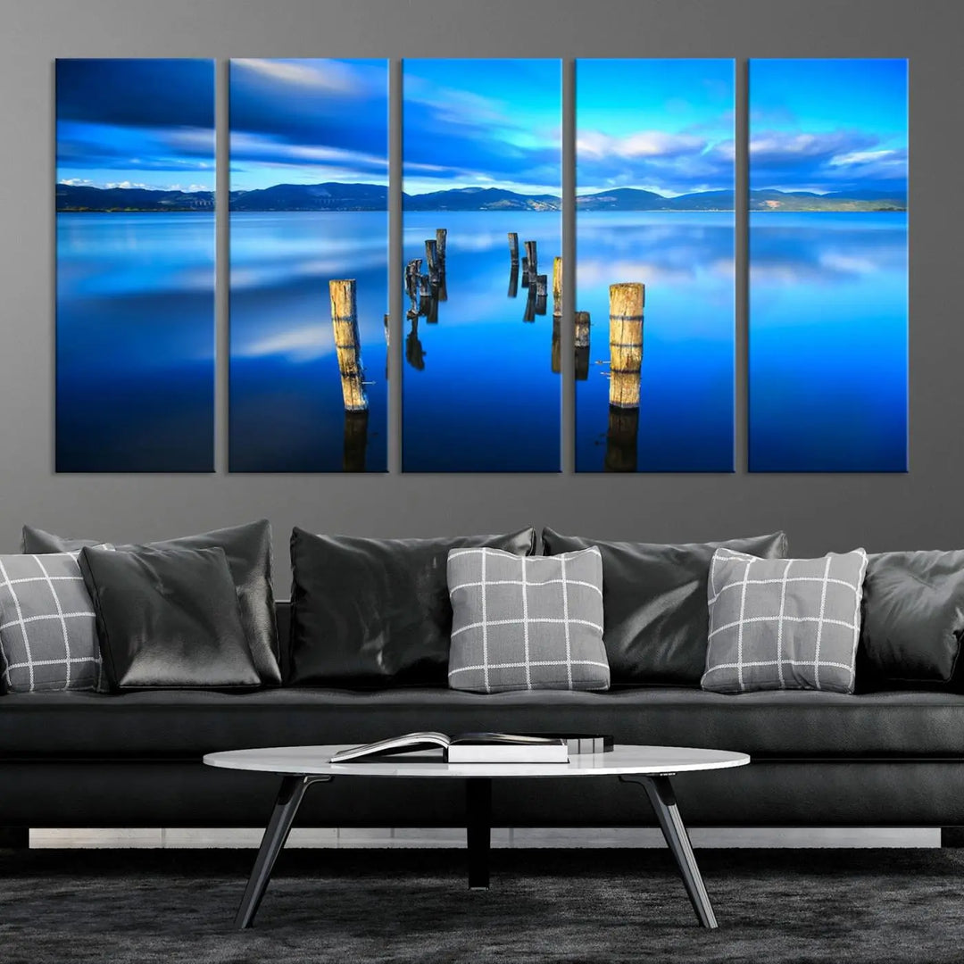 The Calm Waters Lake Canvas Art, featuring a tranquil pier reflection set against a mountainous backdrop, showcases its elegance with a gallery wrap and Canon print quality.