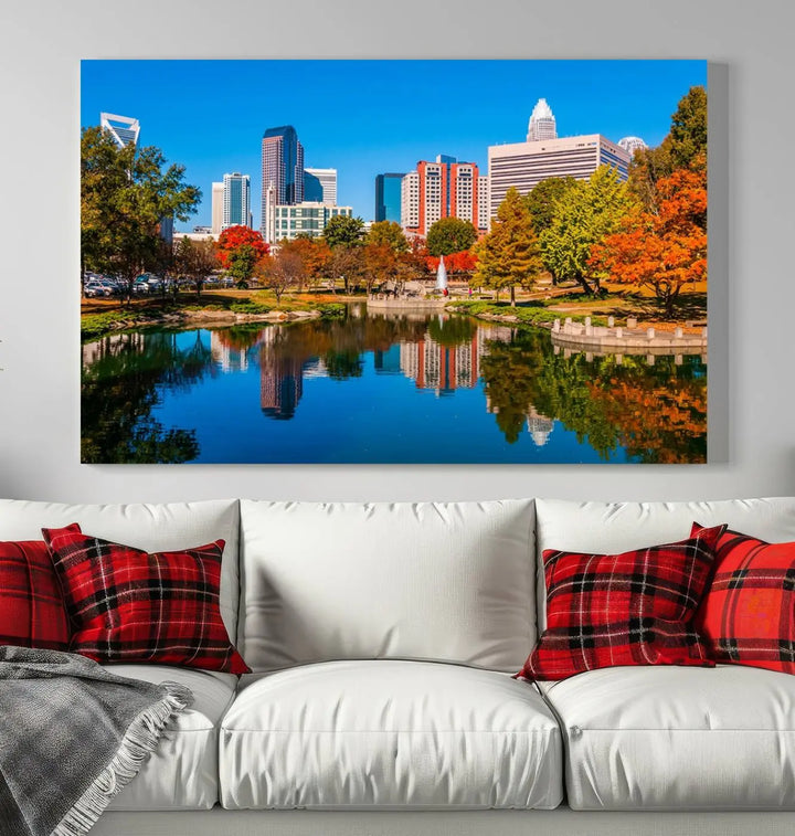 The "Charlotte City Autumn Morning Blue Skyline Cityscape View Wall Art Canvas Print" showcases a cityscape with vibrant autumn trees reflected in a lake. Its gallery-wrapped edges add depth to the scene, while the UV-protective coating ensures lasting brilliance.