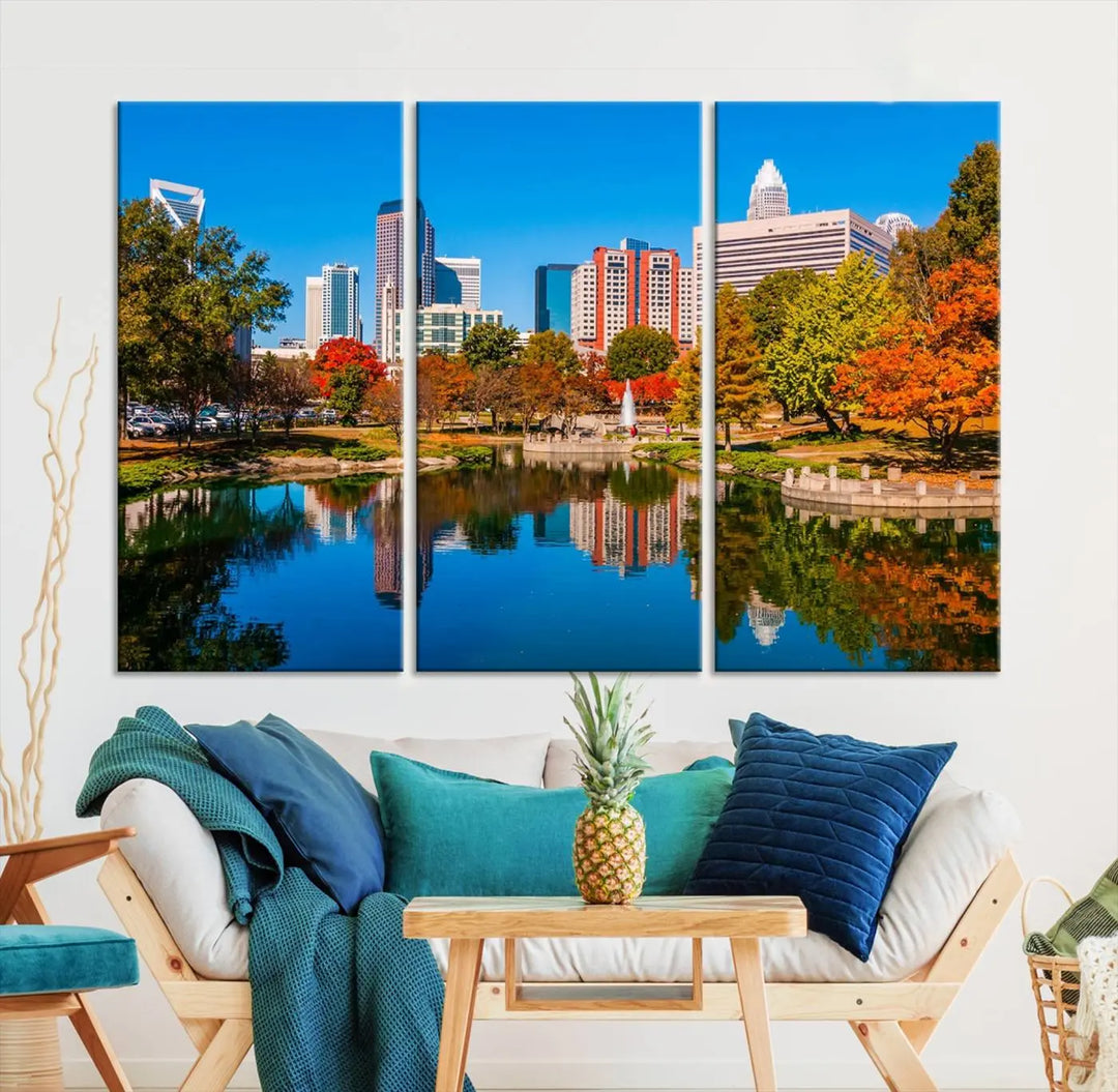 The "Charlotte City Autumn Morning Blue Skyline Cityscape View Wall Art Canvas Print" showcases a cityscape with vibrant autumn trees reflected in a lake. Its gallery-wrapped edges add depth to the scene, while the UV-protective coating ensures lasting brilliance.