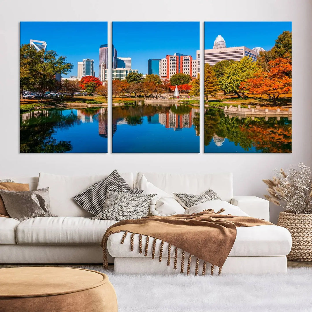 The "Charlotte City Autumn Morning Blue Skyline Cityscape View Wall Art Canvas Print" showcases a cityscape with vibrant autumn trees reflected in a lake. Its gallery-wrapped edges add depth to the scene, while the UV-protective coating ensures lasting brilliance.