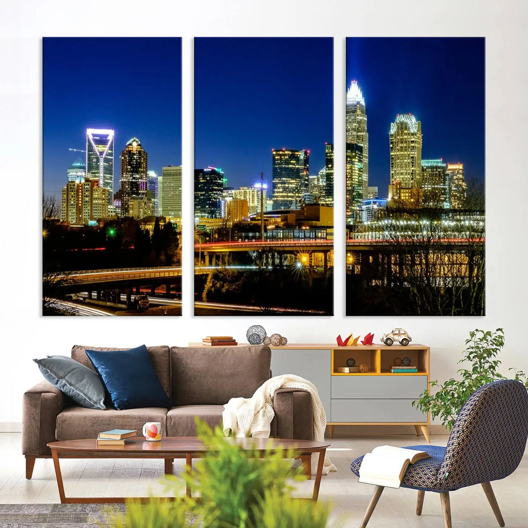 The Charlotte City Lights Night Blue Skyline Cityscape View Wall Art Canvas Print, showcasing an illuminated city skyline at night, is printed on museum-quality canvas with a UV-protective coating. Enhance your space with this stunning piece and enjoy free shipping with your purchase.