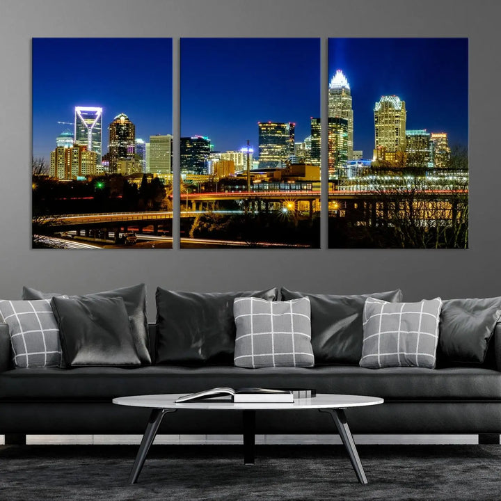 The Charlotte City Lights Night Blue Skyline Cityscape View Wall Art Canvas Print, showcasing an illuminated city skyline at night, is printed on museum-quality canvas with a UV-protective coating. Enhance your space with this stunning piece and enjoy free shipping with your purchase.