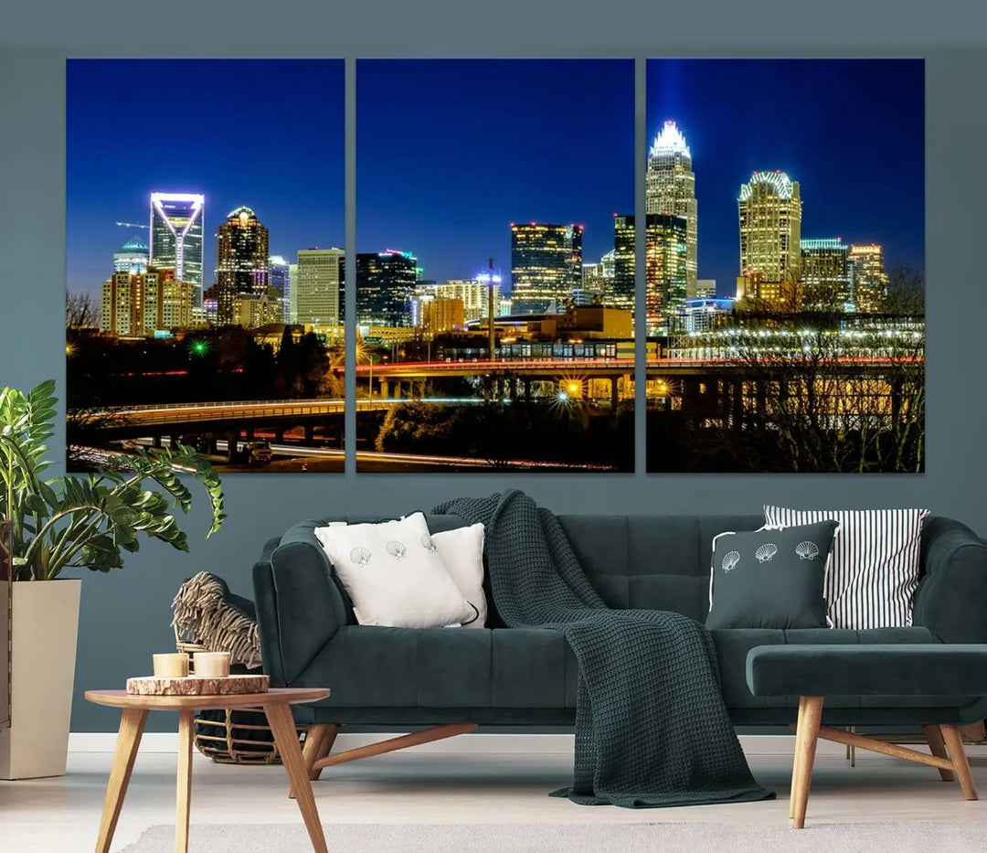 The Charlotte City Lights Night Blue Skyline Cityscape View Wall Art Canvas Print, showcasing an illuminated city skyline at night, is printed on museum-quality canvas with a UV-protective coating. Enhance your space with this stunning piece and enjoy free shipping with your purchase.