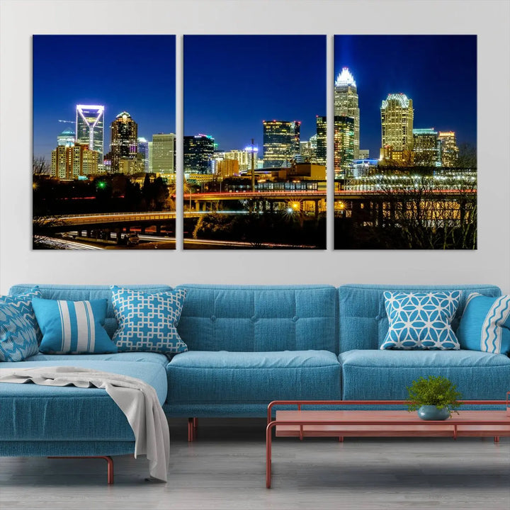 The Charlotte City Lights Night Blue Skyline Cityscape View Wall Art Canvas Print, showcasing an illuminated city skyline at night, is printed on museum-quality canvas with a UV-protective coating. Enhance your space with this stunning piece and enjoy free shipping with your purchase.