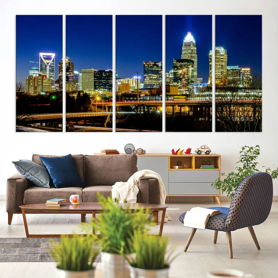 The Charlotte City Lights Night Blue Skyline Cityscape View Wall Art Canvas Print, showcasing an illuminated city skyline at night, is printed on museum-quality canvas with a UV-protective coating. Enhance your space with this stunning piece and enjoy free shipping with your purchase.