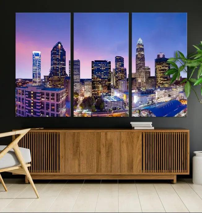 The Charlotte City Lights Sunset Purple Skyline Cityscape View Wall Art Canvas Print showcases a triptych of a city skyline with illuminated skyscrapers at dusk.