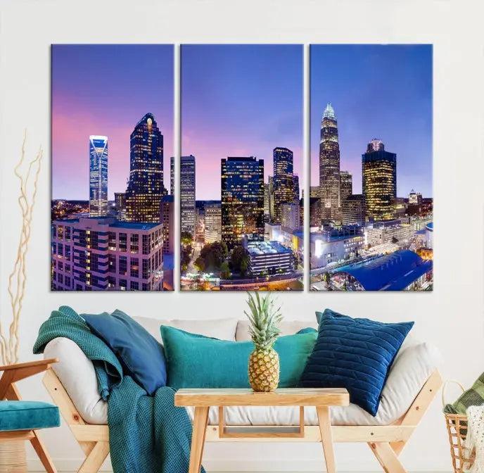 The Charlotte City Lights Sunset Purple Skyline Cityscape View Wall Art Canvas Print showcases a triptych of a city skyline with illuminated skyscrapers at dusk.