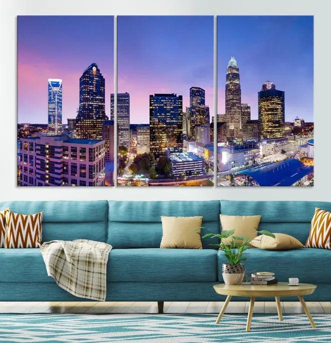 The Charlotte City Lights Sunset Purple Skyline Cityscape View Wall Art Canvas Print showcases a triptych of a city skyline with illuminated skyscrapers at dusk.