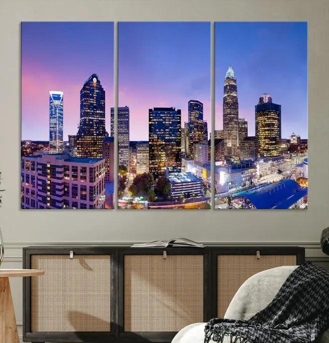 The Charlotte City Lights Sunset Purple Skyline Cityscape View Wall Art Canvas Print showcases a triptych of a city skyline with illuminated skyscrapers at dusk.