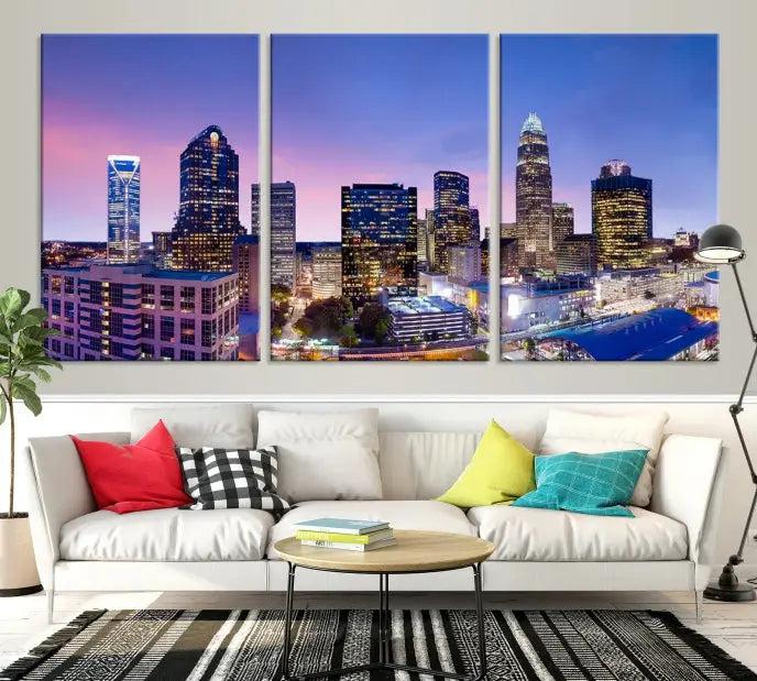 The Charlotte City Lights Sunset Purple Skyline Cityscape View Wall Art Canvas Print showcases a triptych of a city skyline with illuminated skyscrapers at dusk.