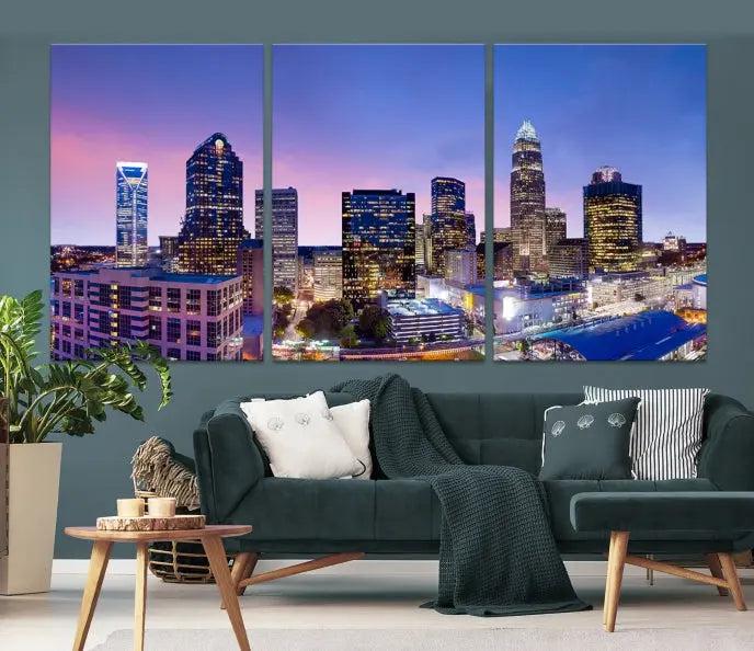 The Charlotte City Lights Sunset Purple Skyline Cityscape View Wall Art Canvas Print showcases a triptych of a city skyline with illuminated skyscrapers at dusk.