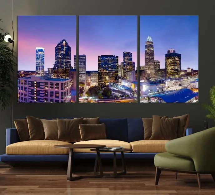 The Charlotte City Lights Sunset Purple Skyline Cityscape View Wall Art Canvas Print showcases a triptych of a city skyline with illuminated skyscrapers at dusk.