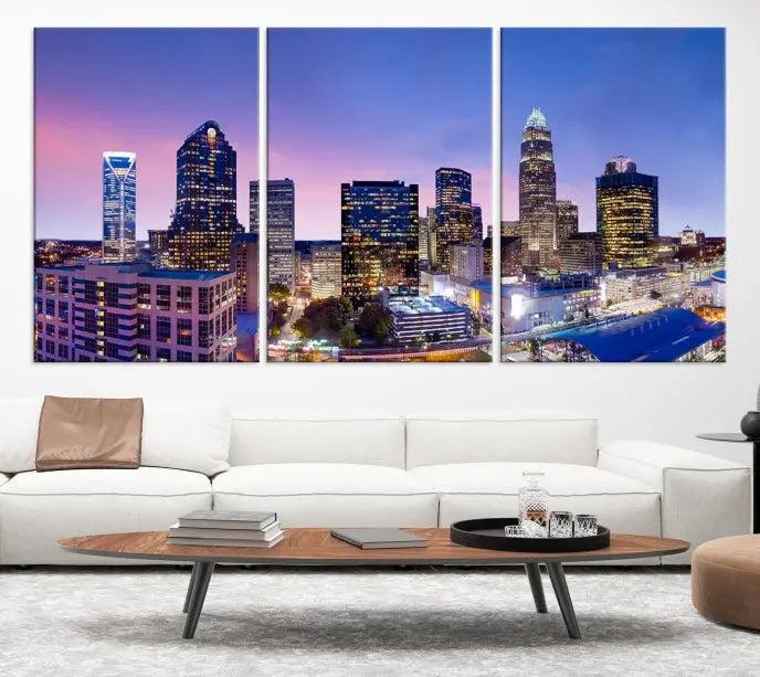 The Charlotte City Lights Sunset Purple Skyline Cityscape View Wall Art Canvas Print showcases a triptych of a city skyline with illuminated skyscrapers at dusk.