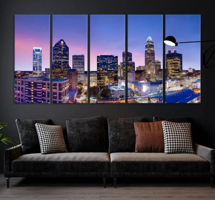 The Charlotte City Lights Sunset Purple Skyline Cityscape View Wall Art Canvas Print showcases a triptych of a city skyline with illuminated skyscrapers at dusk.