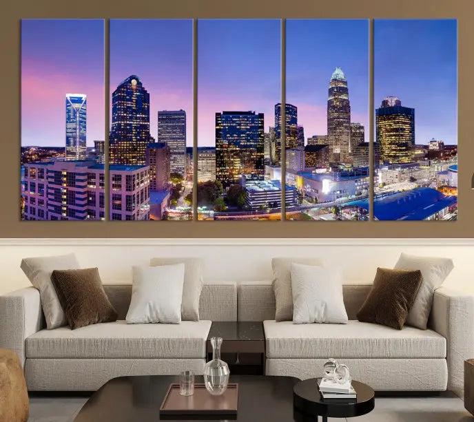 The Charlotte City Lights Sunset Purple Skyline Cityscape View Wall Art Canvas Print showcases a triptych of a city skyline with illuminated skyscrapers at dusk.