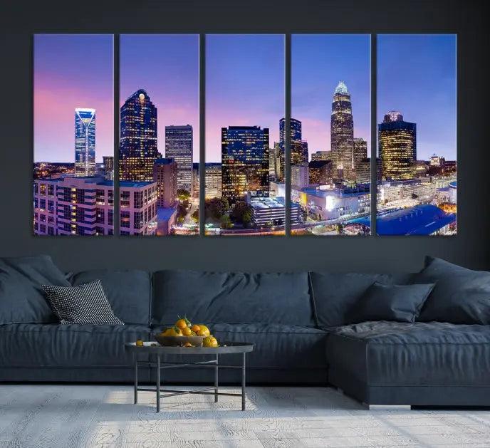 The Charlotte City Lights Sunset Purple Skyline Cityscape View Wall Art Canvas Print showcases a triptych of a city skyline with illuminated skyscrapers at dusk.