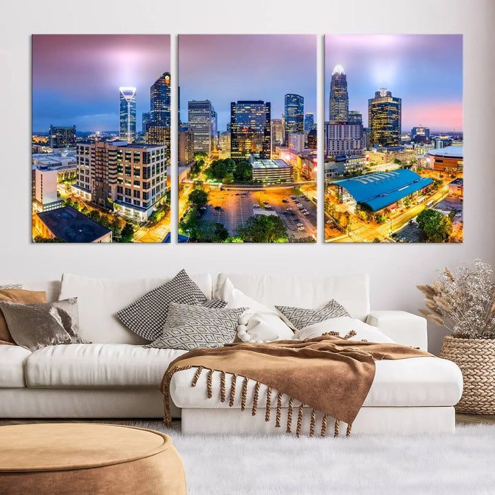 The "Charlotte City Lights Sunset Purple Skyline Cityscape View Wall Art Canvas Print" features a triptych of a vibrant city skyline at dusk, highlighting illuminated skyscrapers and urban streets. This artwork is crafted on museum-quality polycotton canvas, with its gallery-wrapped design ensuring durability and visual appeal for years to come.