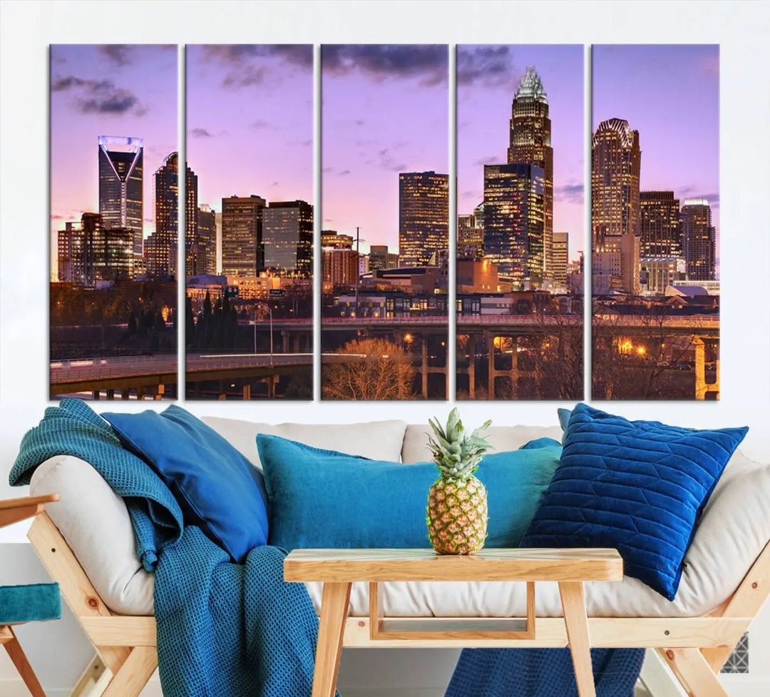 The "Charlotte City Lights Sunset Purple Skyline Cityscape View Wall Art Canvas Print" adorns the modern living room. This museum-quality piece is ready to hang and features a UV-protective coating to preserve its vibrant colors for years.