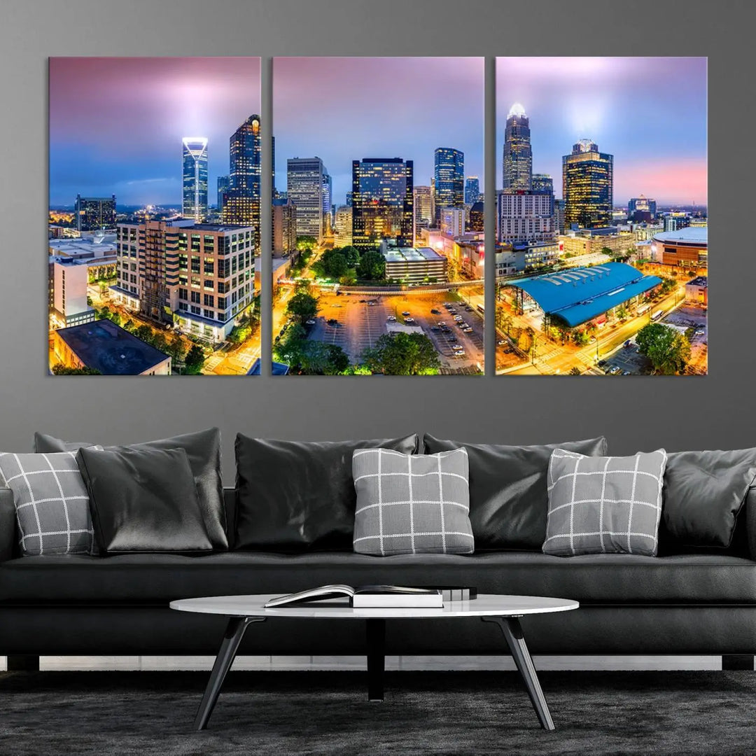 The living room features three large pieces of the *Charlotte City Lights Sunset Purple Skyline Cityscape View Wall Art Canvas Print*. Crafted on gallery-wrapped, museum-quality canvas with UV-protective coating, they grace the wall and add an artistic flair to the space.