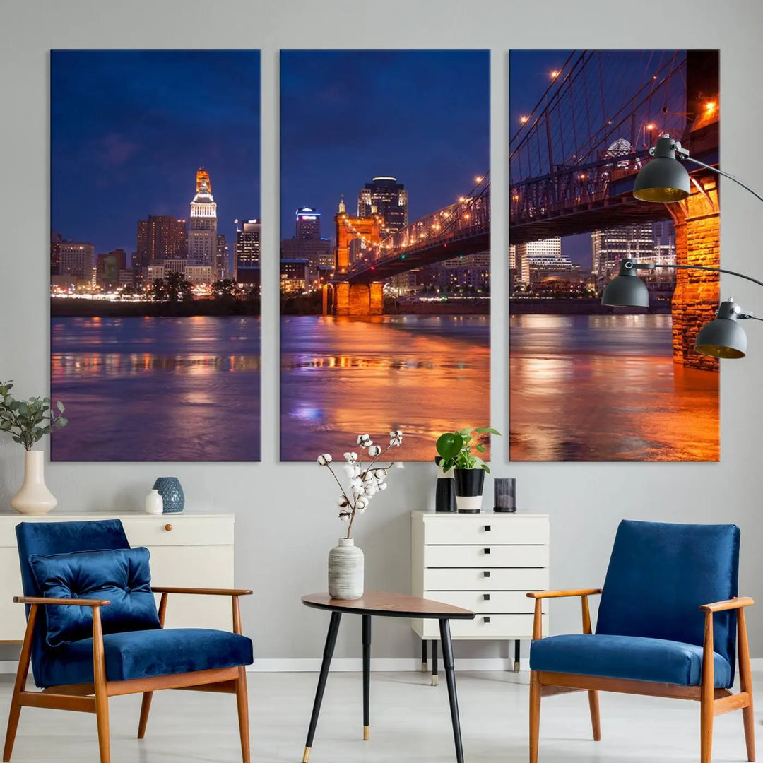 The Cincinnati City Bridge Lights Night Skyline Cityscape View Wall Art Canvas Print is a magnificent triptych crafted on museum-quality polycotton canvas. It features a beautifully illuminated bridge over water at night, enhancing any living room with its elegant design.