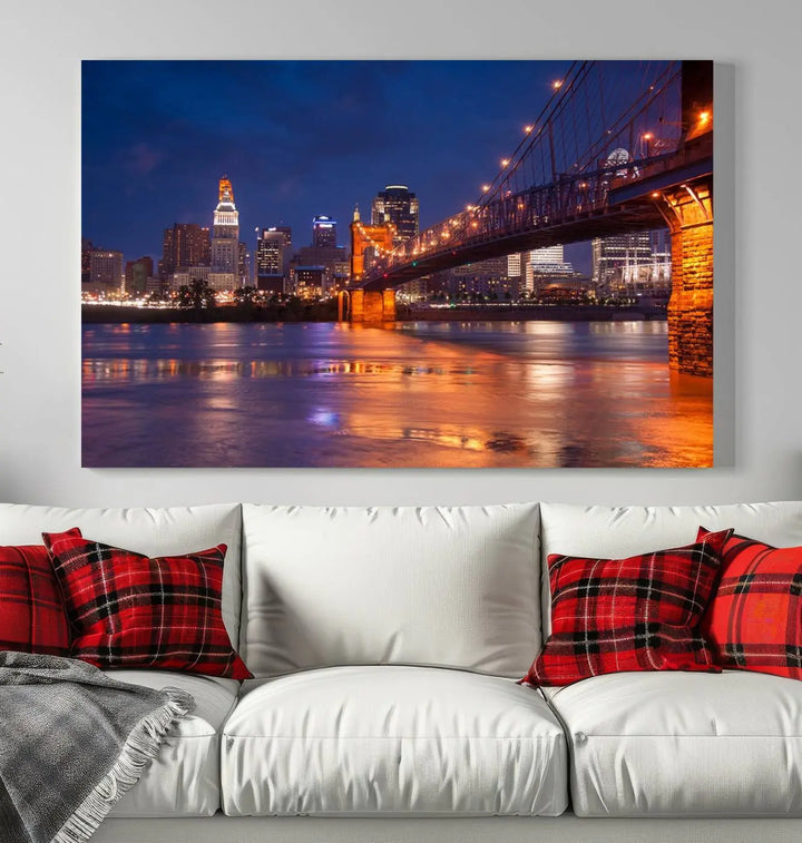 The Cincinnati City Bridge Lights Night Skyline Cityscape View Wall Art Canvas Print is a magnificent triptych crafted on museum-quality polycotton canvas. It features a beautifully illuminated bridge over water at night, enhancing any living room with its elegant design.