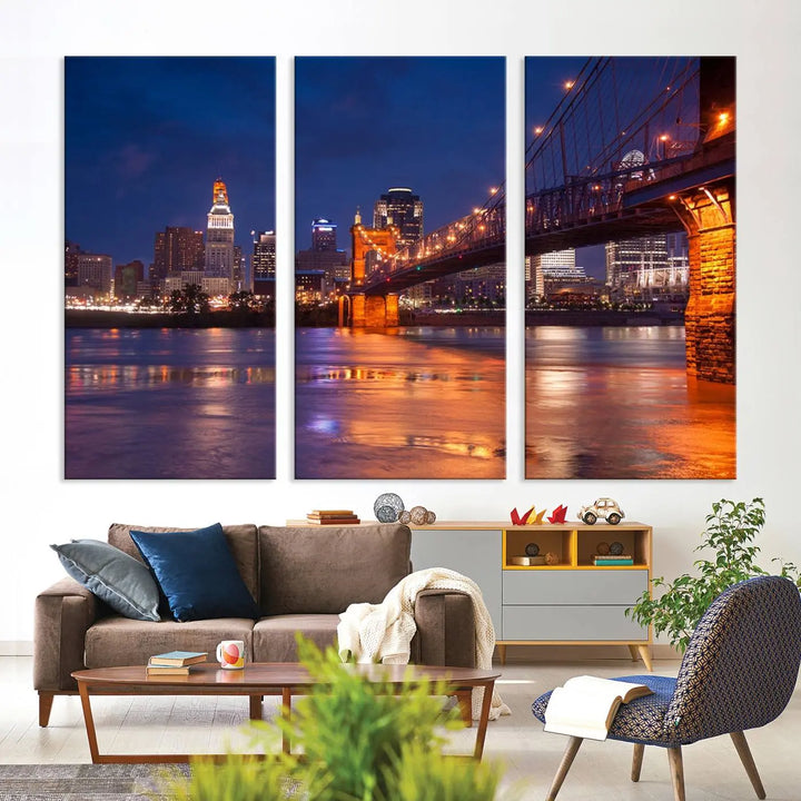 The Cincinnati City Bridge Lights Night Skyline Cityscape View Wall Art Canvas Print is a magnificent triptych crafted on museum-quality polycotton canvas. It features a beautifully illuminated bridge over water at night, enhancing any living room with its elegant design.