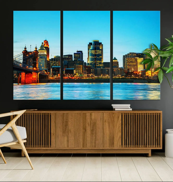 The "Cincinnati City Lights Bright Blue Skyline Cityscape View Wall Art Canvas Print" is displayed as a three-panel masterpiece. Expertly crafted on museum-quality polycotton canvas with a UV-protective coating, this artwork captures the essence of the city at dusk.