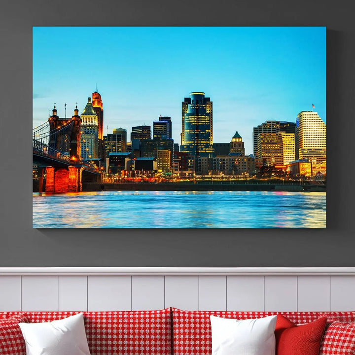 The "Cincinnati City Lights Bright Blue Skyline Cityscape View Wall Art Canvas Print" is displayed as a three-panel masterpiece. Expertly crafted on museum-quality polycotton canvas with a UV-protective coating, this artwork captures the essence of the city at dusk.