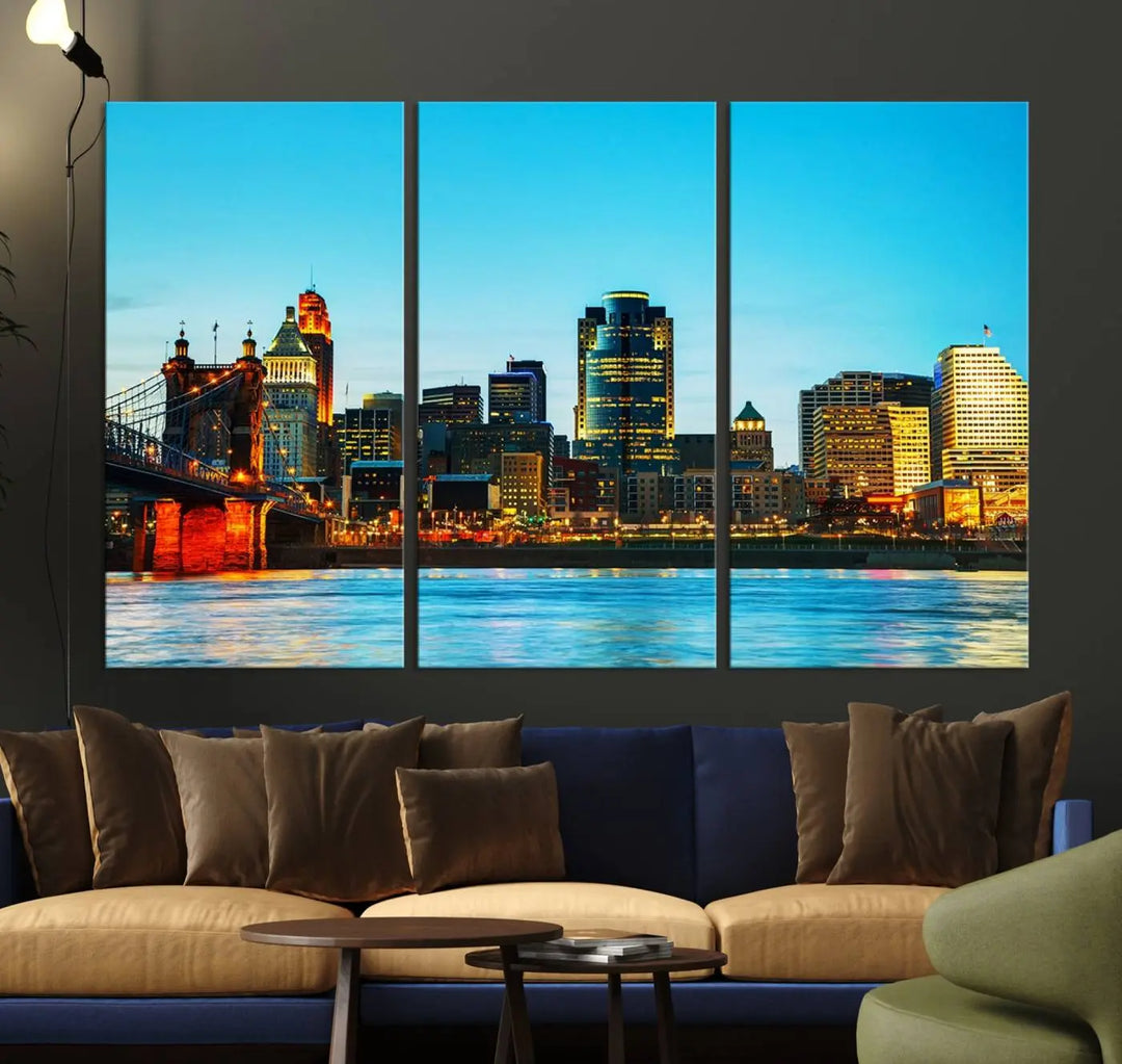 The "Cincinnati City Lights Bright Blue Skyline Cityscape View Wall Art Canvas Print" is displayed as a three-panel masterpiece. Expertly crafted on museum-quality polycotton canvas with a UV-protective coating, this artwork captures the essence of the city at dusk.