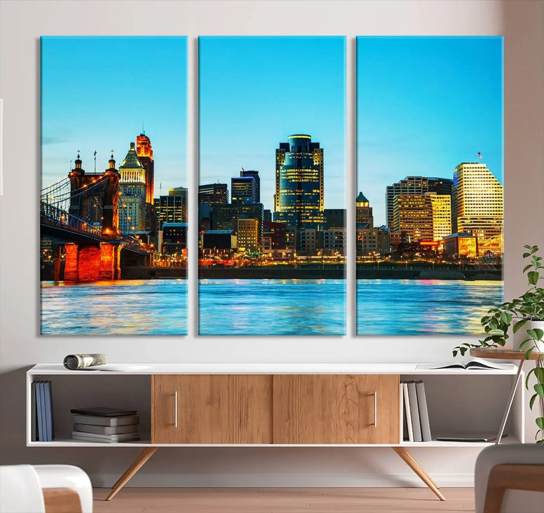 The "Cincinnati City Lights Bright Blue Skyline Cityscape View Wall Art Canvas Print" is displayed as a three-panel masterpiece. Expertly crafted on museum-quality polycotton canvas with a UV-protective coating, this artwork captures the essence of the city at dusk.