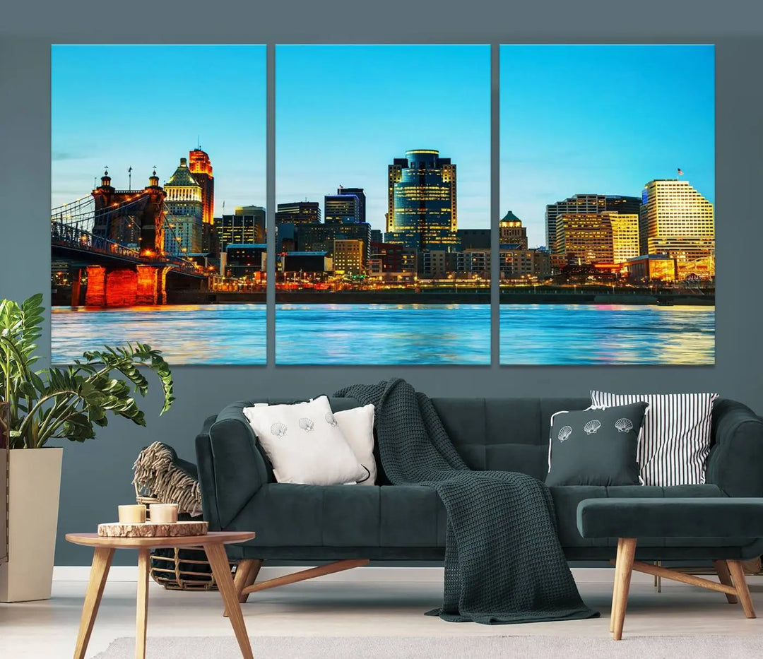 The "Cincinnati City Lights Bright Blue Skyline Cityscape View Wall Art Canvas Print" is displayed as a three-panel masterpiece. Expertly crafted on museum-quality polycotton canvas with a UV-protective coating, this artwork captures the essence of the city at dusk.